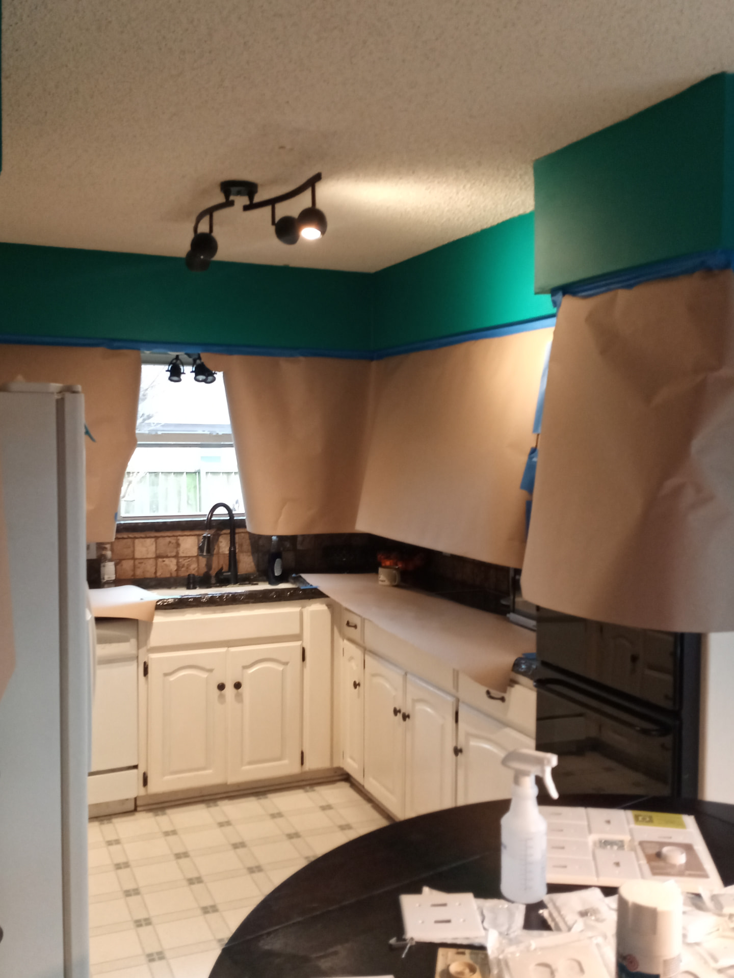 Kitchen masked and papered off with fresh green paint on the upper walls
