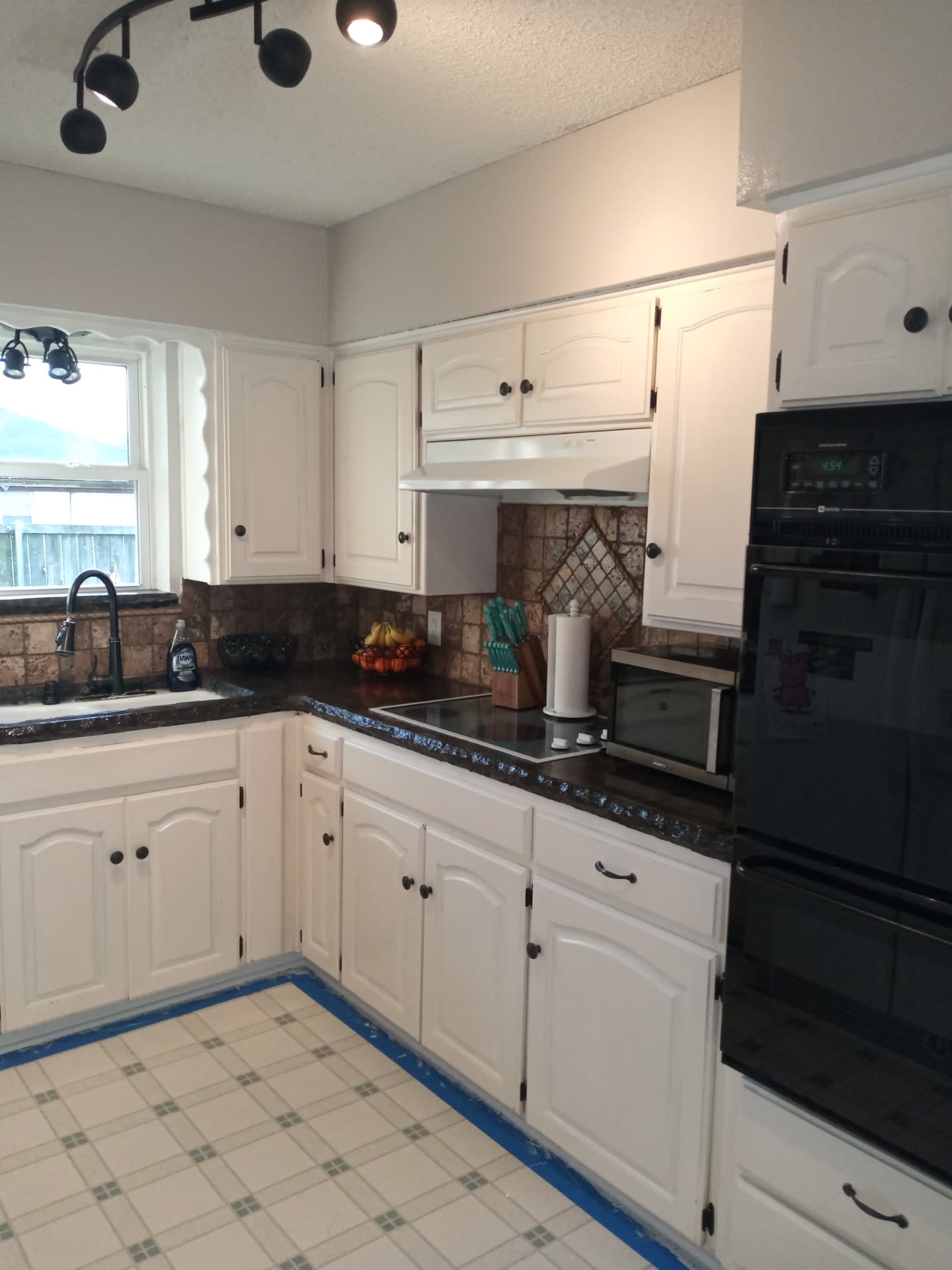 Finished kitchen remodel with repainted white cabinets and walls