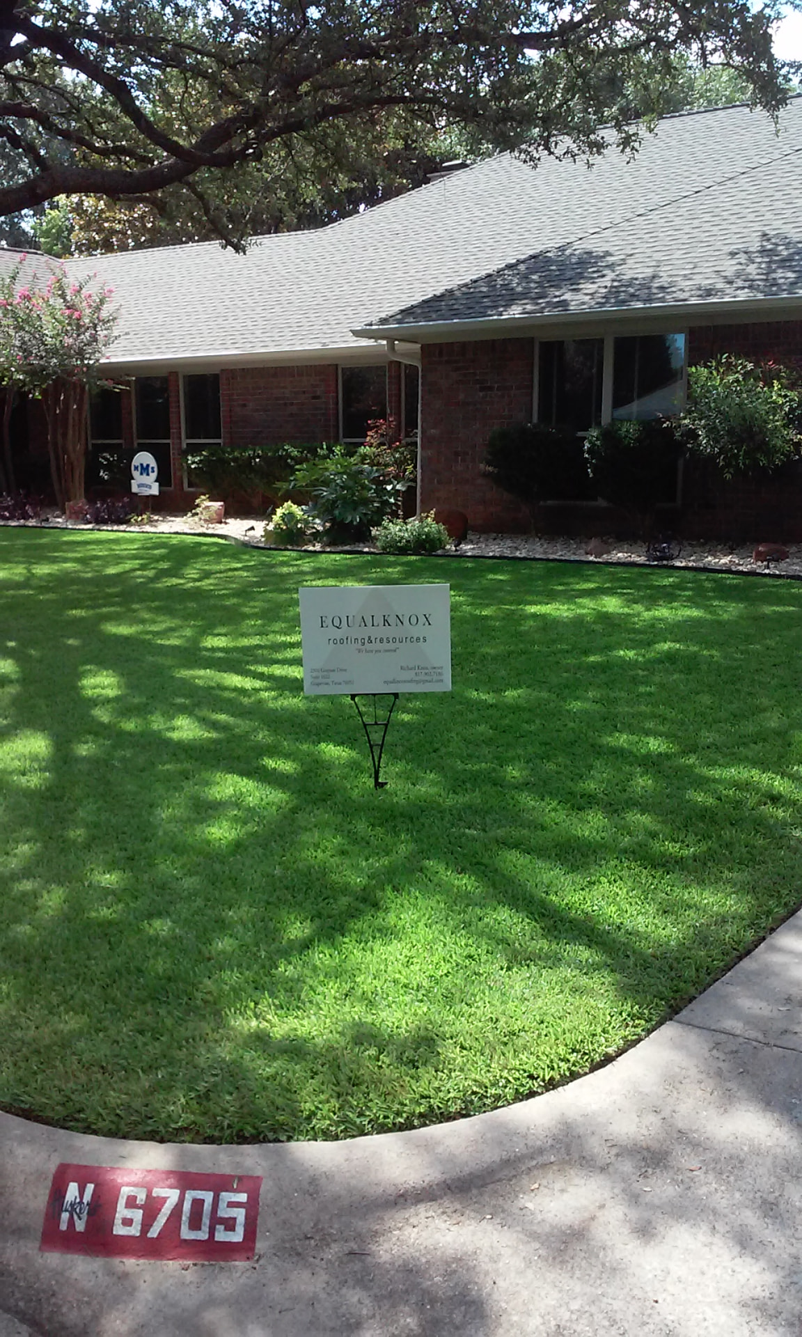 EqualKnox yard sign on a shaded lawn in front of a brick ranch home with a new shingle roof