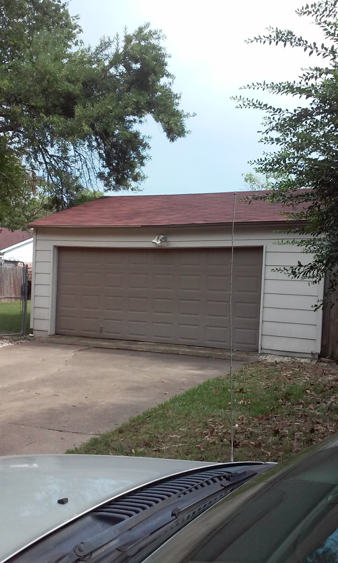 Detached two-car garage with a newly installed red shingle roof
